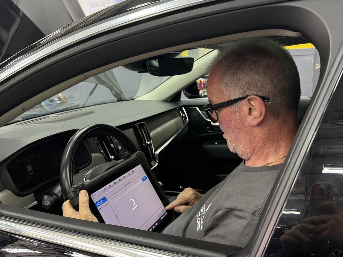 A First Call Auto Care technician running a diagnostic scan from the driver's seat of a vehicle in Royal Oak