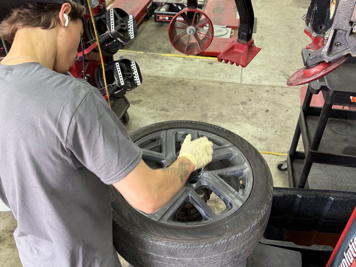 A technician seating a tire onto its wheel on the tire machine at First Call Auto Care in Royal Oak