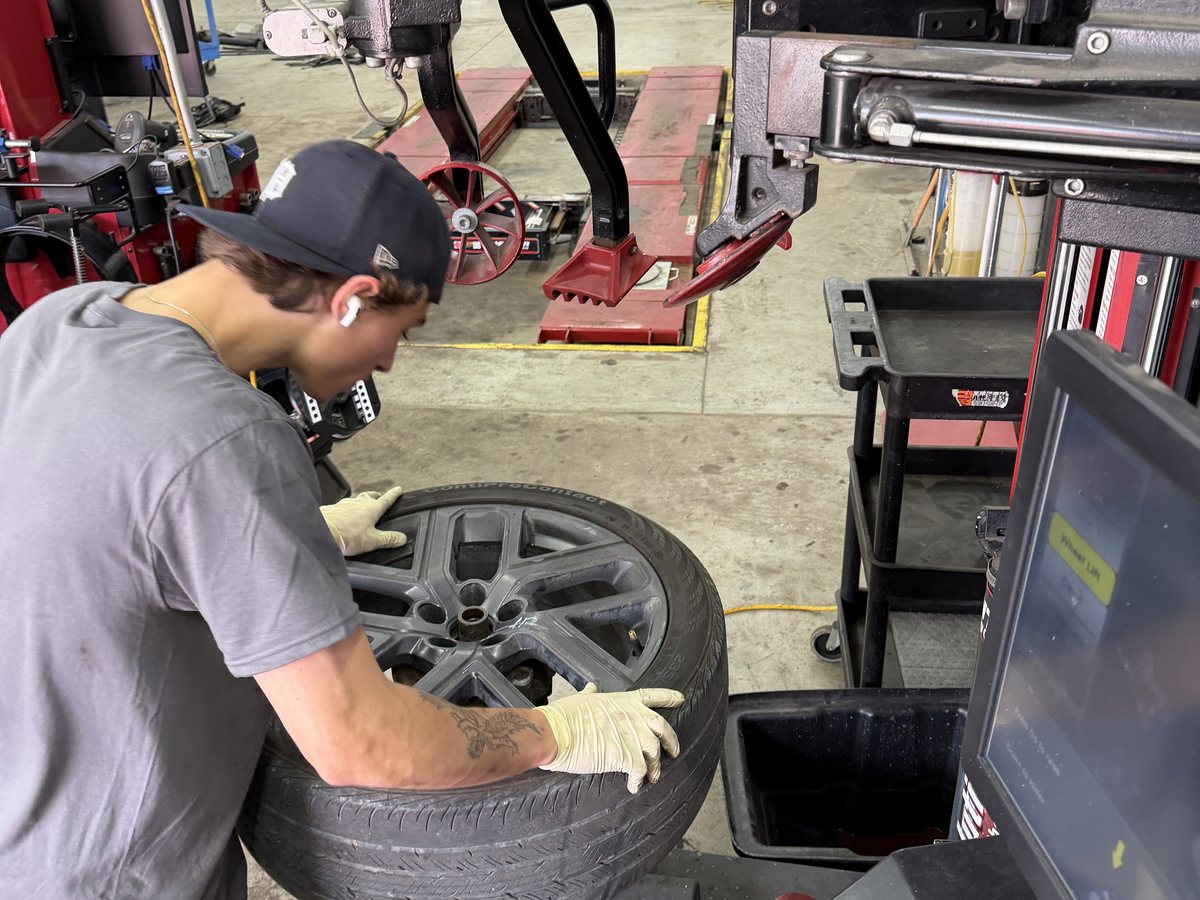 A First Call Auto Care technician mounting a tire on the tire machine at the Royal Oak shop